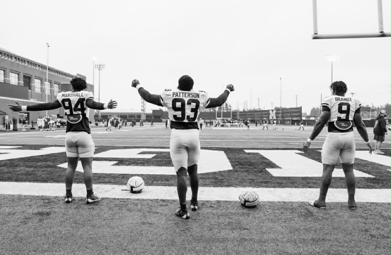 Three football players entering the field
